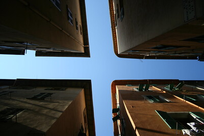 Fotografía del cielo, cubierto en parte por cuatro edificios, en cuatro esquinas, los cuales forman un cruce de caminos en el aire.